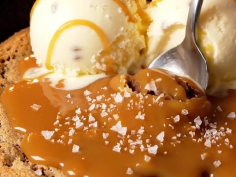 Warm skillet pizookie with vanilla gelato and caramel drizzle
