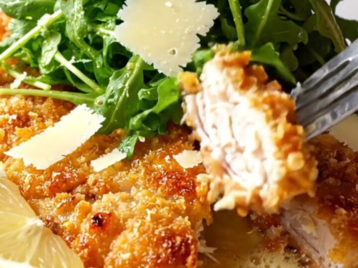 Golden crispy chicken cutlets topped with lemon arugula salad and shaved parmesan