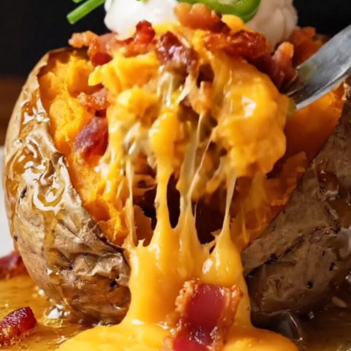 Loaded Hasselback sweet potatoes with melted cheddar and bacon, topped with jalapeño and sour cream