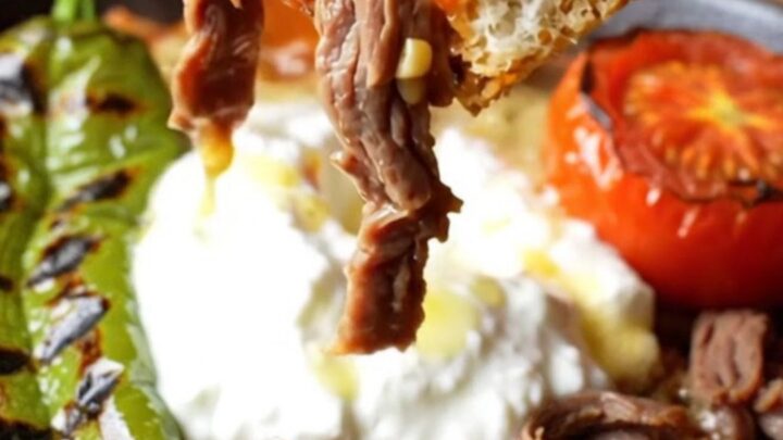 İskender kebab platter with shaved meat, toasted pide, tomato sauce, garlic yogurt, and sizzling browned butter