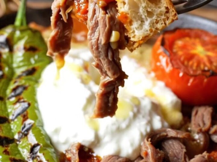 İskender kebab platter with shaved meat, toasted pide, tomato sauce, garlic yogurt, and sizzling browned butter