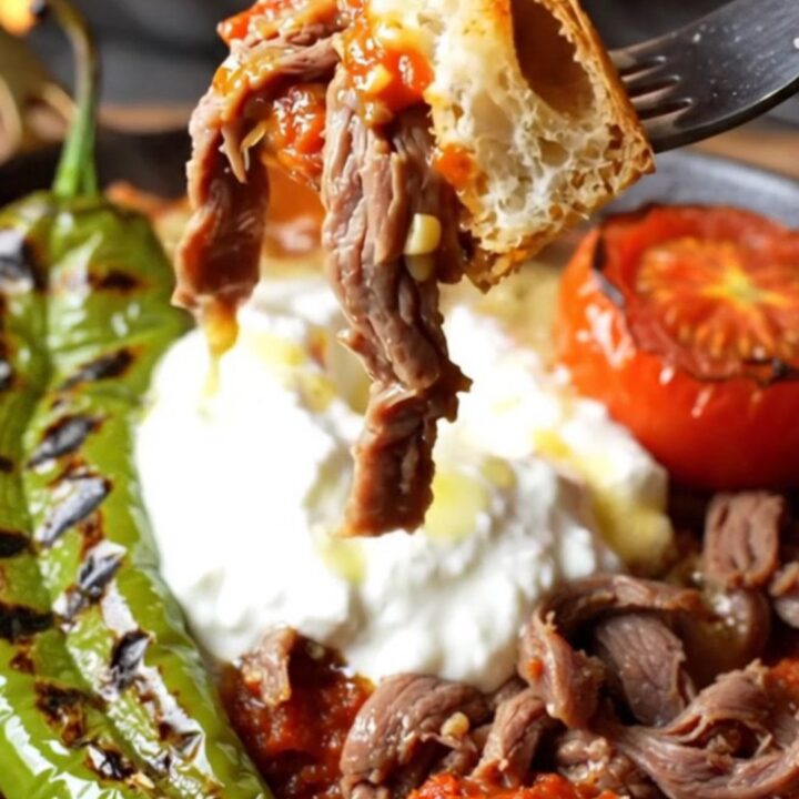 İskender kebab platter with shaved meat, toasted pide, tomato sauce, garlic yogurt, and sizzling browned butter
