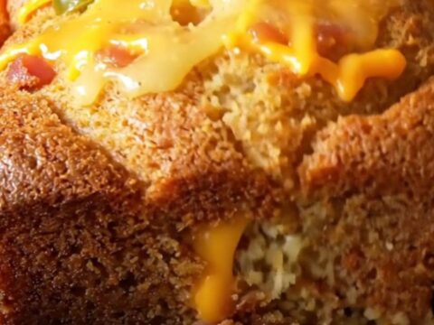 Loaded cornbread skillet with melted cheese and bacon, golden crust