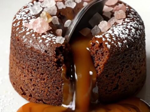 Molten salted caramel dark chocolate fondant cake with powdered sugar and flaky sea salt