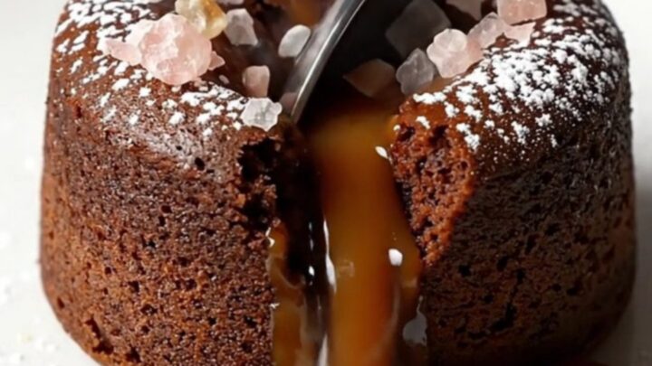 Molten salted caramel dark chocolate fondant cake with powdered sugar and flaky sea salt