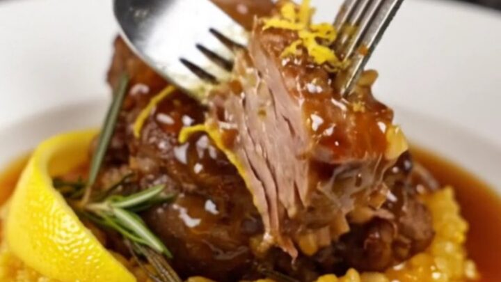 Slow-braised veal shank on a bed of golden saffron risotto, garnished with rosemary.