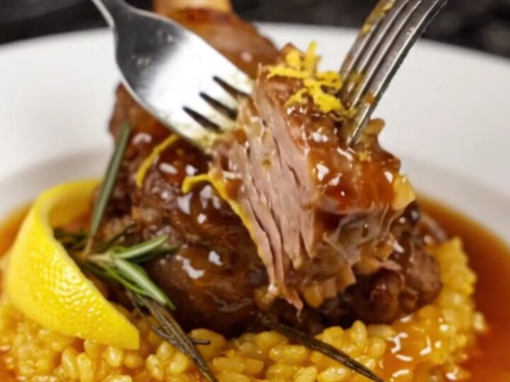 Slow-braised veal shank on a bed of golden saffron risotto, garnished with rosemary.