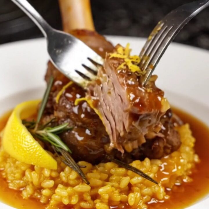 Slow-braised veal shank on a bed of golden saffron risotto, garnished with rosemary.