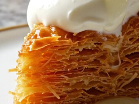 Golden twisted Burma Kadayıf with pistachios and kaymak on a plate