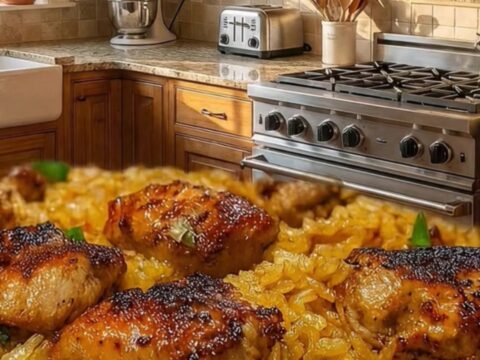 Golden roasted chicken thighs on a bed of fluffy rice in a rustic skillet