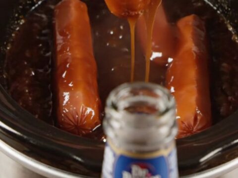 Glossy Dr Pepper BBQ Lil' Smokies in a slow cooker with a dark, syrupy sauce