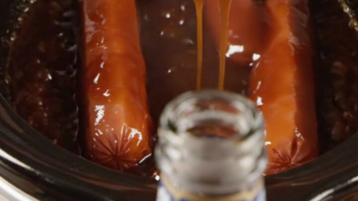 Glossy Dr Pepper BBQ Lil' Smokies in a slow cooker with a dark, syrupy sauce