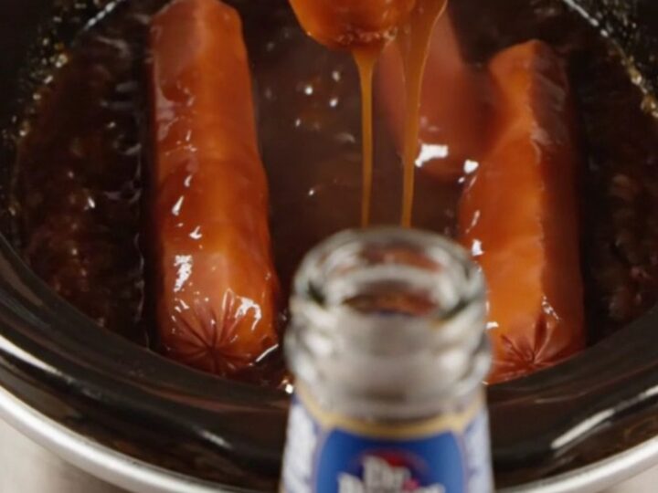 Glossy Dr Pepper BBQ Lil' Smokies in a slow cooker with a dark, syrupy sauce
