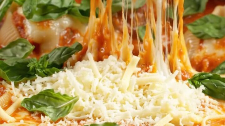 One-pan stuffed jumbo shells with meatballs in a skillet, topped with blistered mozzarella and fresh basil.