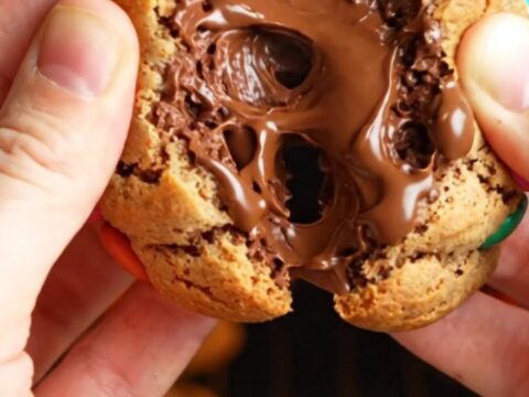 Thick bakery-style M&M cookies with golden edges and soft centers, studded with colorful candies and chocolate chunks.