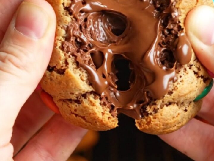 Thick bakery-style M&M cookies with golden edges and soft centers, studded with colorful candies and chocolate chunks.