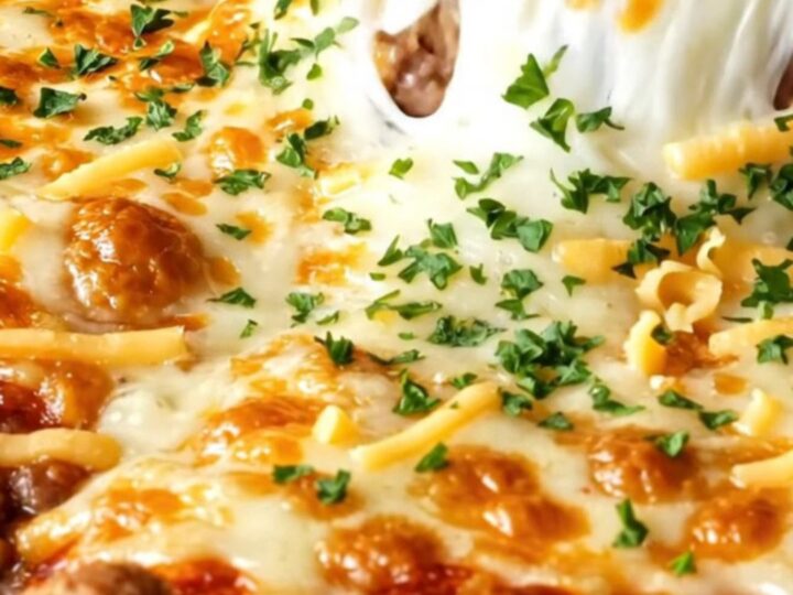Golden, bubbling casserole pie with melted cheese pull and beef filling