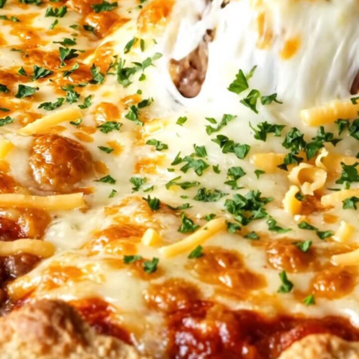 Golden, bubbling casserole pie with melted cheese pull and beef filling