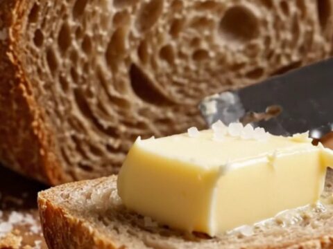 A dark golden sourdough boule with a blistered crust, sliced to show an airy crumb
