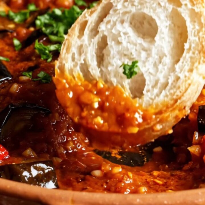 Turkish meatball and roasted eggplant casserole in a baking dish, with caramelized vegetables and parsley garnish