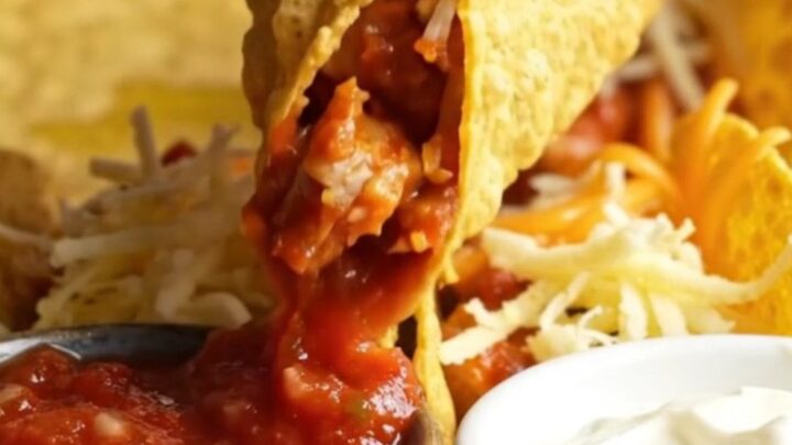 Golden baked chicken tacos with melted cheese on a sheet pan, ready to serve