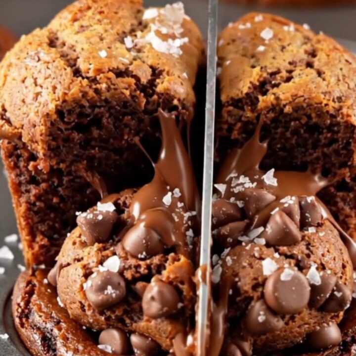 Brown butter brookie cups broken open showing fudgy brownie and cookie layers with melted chocolate.