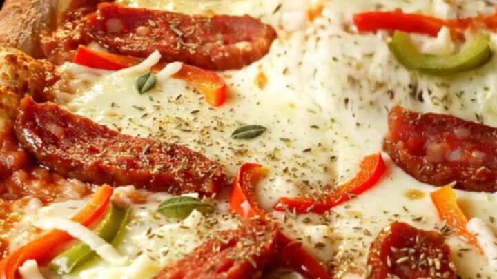 Fluffy Turkish sheet-pan pizza with melted mozzarella, sucuk slices, and bell peppers, cut into squares.