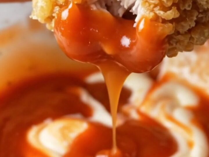 Crispy golden chicken tenders tossed with parmesan and garlic butter, with a bowl of creamy sweet chili sauce for dipping.