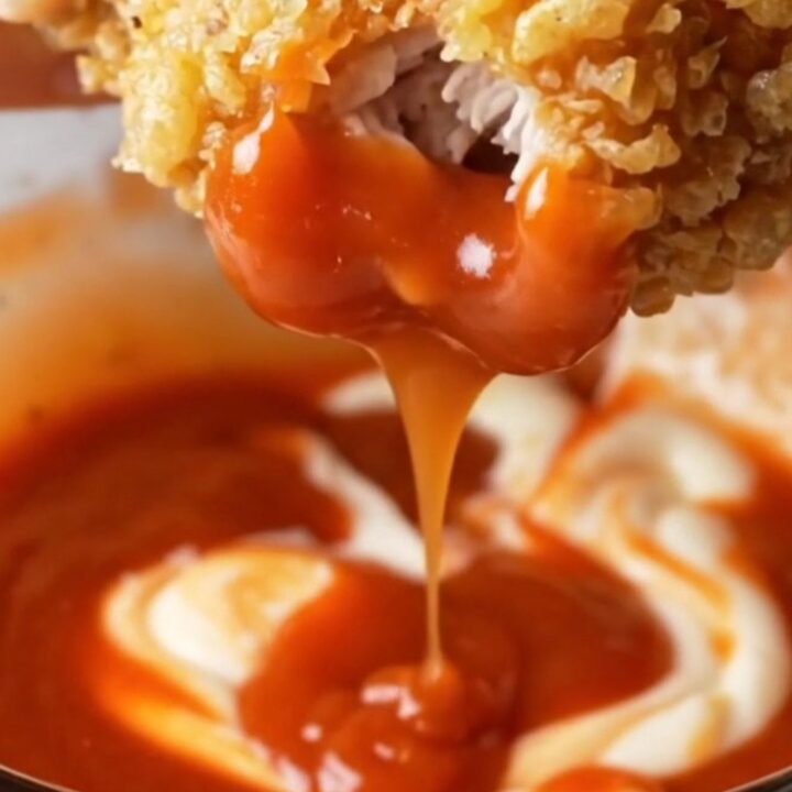 Crispy golden chicken tenders tossed with parmesan and garlic butter, with a bowl of creamy sweet chili sauce for dipping.