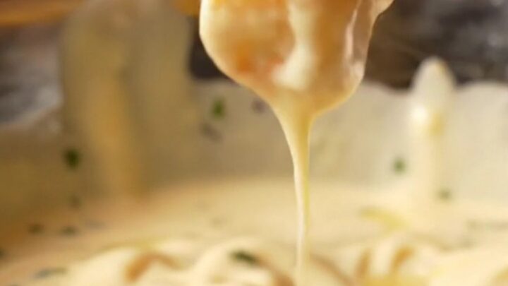Golden crispy fries tossed with garlic butter and Parmesan, with a bowl of creamy garlic aioli for dipping.