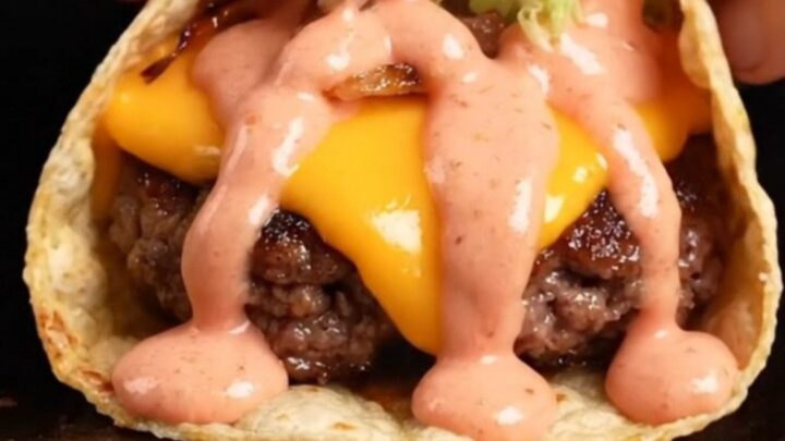 Smash burger tacos with crispy beef, melted cheddar, lettuce, and secret sauce on a plate