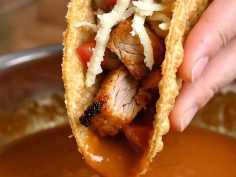 Golden crispy chicken tacos topped with fresh pico de gallo and spicy cream sauce