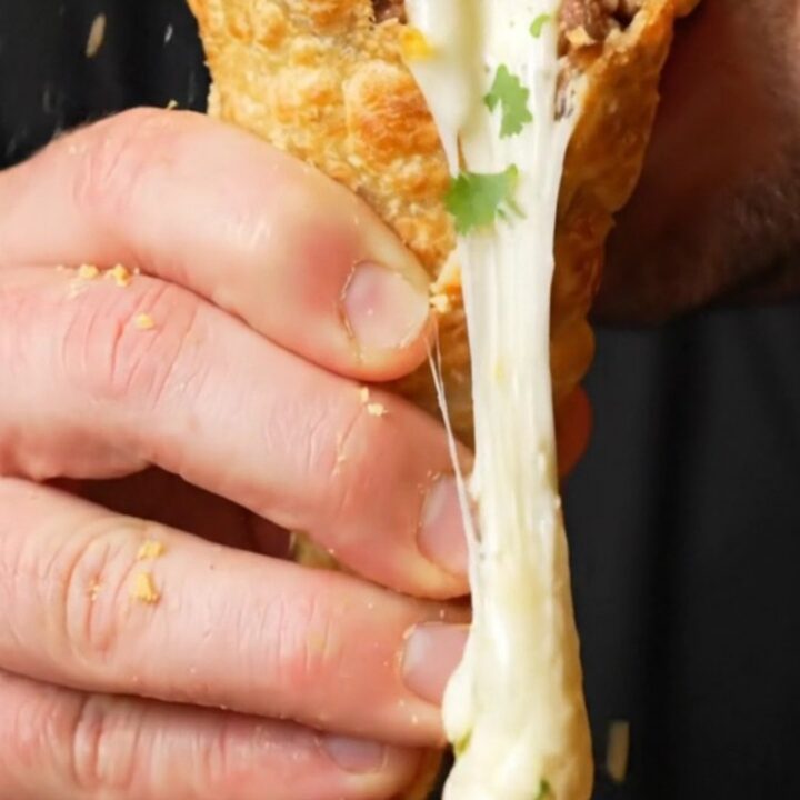 Crispy golden tortilla cone filled with seasoned beef and melted mozzarella, cheese pulling as it's lifted