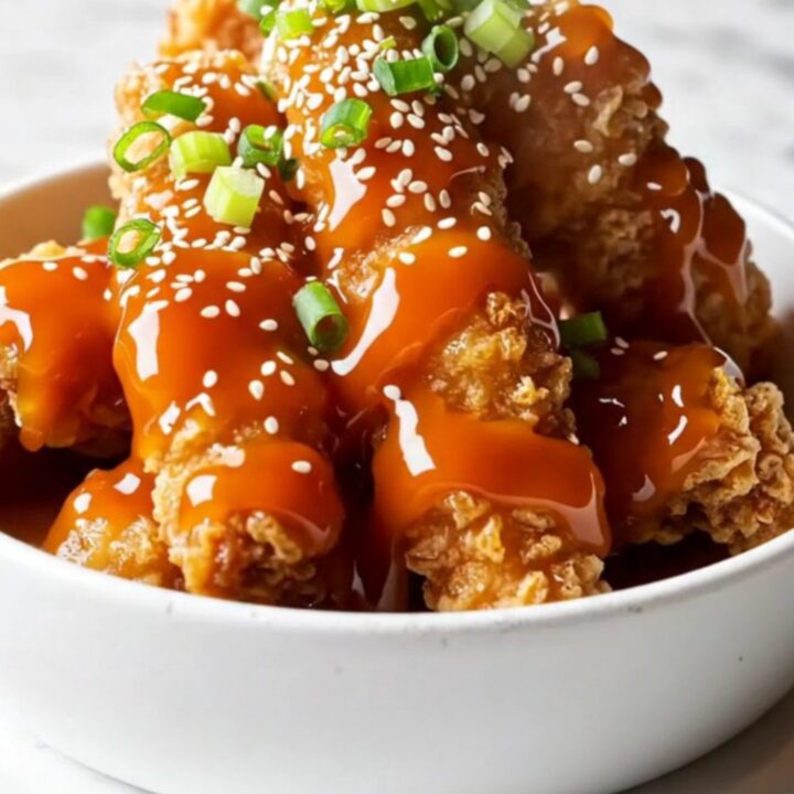 Crispy chicken tenders tossed in honey sriracha glaze, garnished with sesame and scallions.