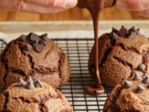 Giant double chocolate chip cookies stacked on a plate, showing gooey chocolate centers