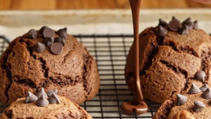 Giant double chocolate chip cookies stacked on a plate, showing gooey chocolate centers