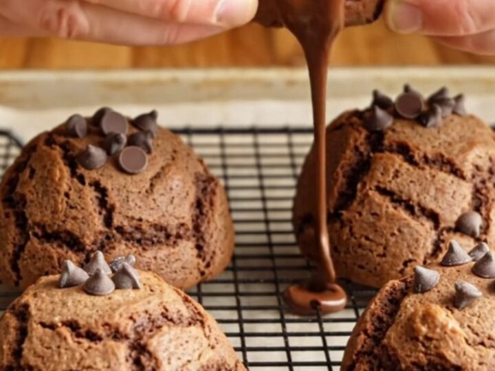 Giant double chocolate chip cookies stacked on a plate, showing gooey chocolate centers