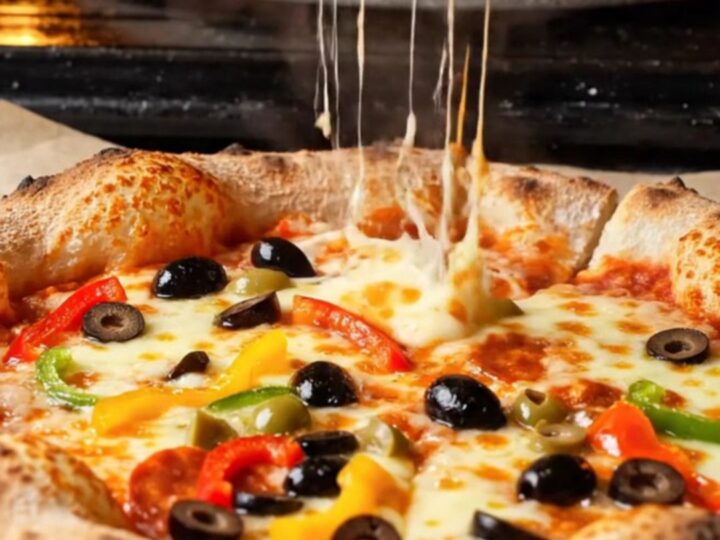 Golden bakery-style pizza with blistered crust and stretchy mozzarella