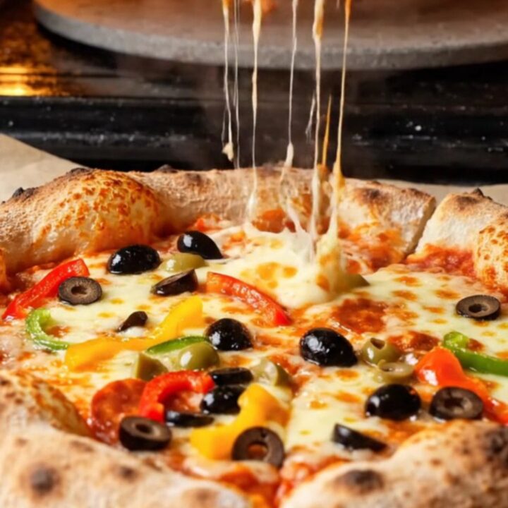 Golden bakery-style pizza with blistered crust and stretchy mozzarella