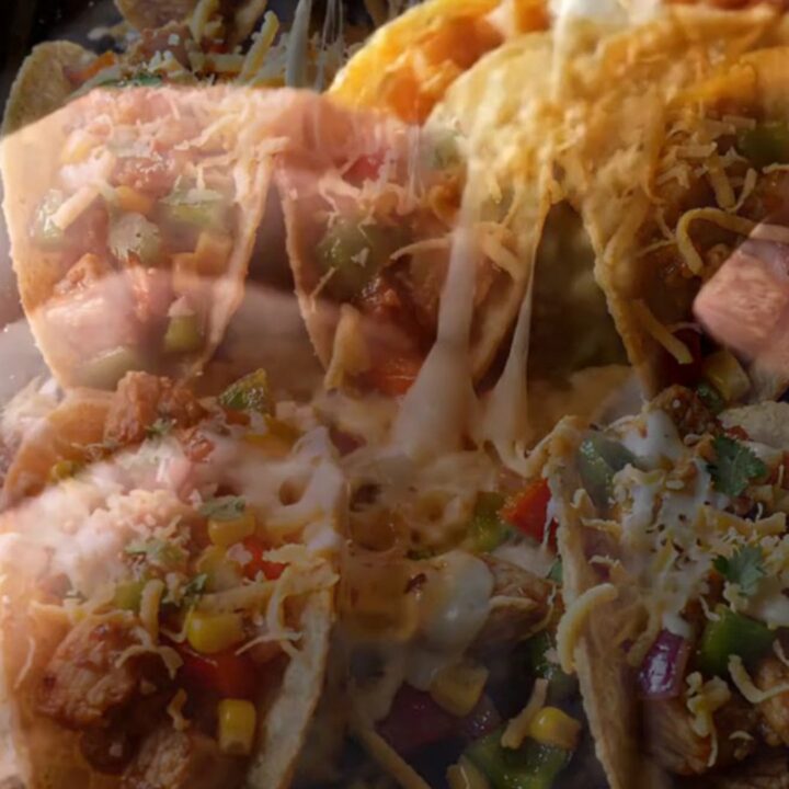 Smoked paprika cheesy taco boats on a baking sheet, topped with melted cheese and chipotle sauce