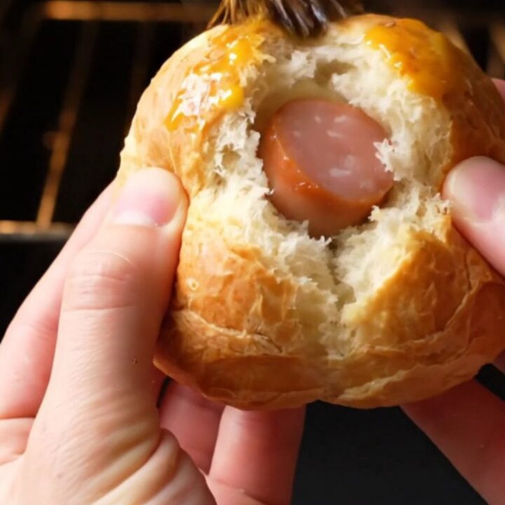 Golden bunny-shaped poğaça buns with sausage surprise on a baking sheet
