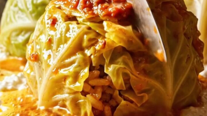 Golden cup-molded Turkish stuffed cabbage rolls on a platter with garlic yogurt and paprika butter