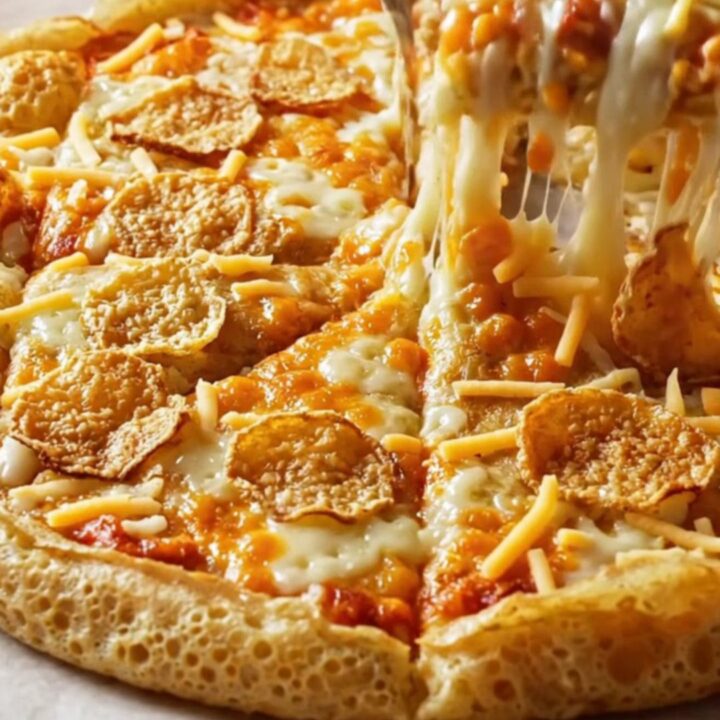 Golden puffy crepe pizza with melted cheese and crispy sucuk slices on a parchment-lined baking sheet.