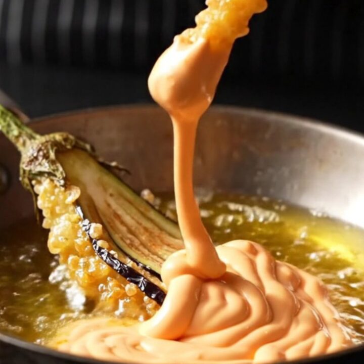 A golden crispy eggplant fan on a wire rack, sprinkled with sea salt and smoked paprika