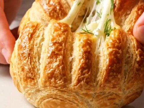 Golden Turkish poğaça buns with dill and feta, broken open to show flaky interior