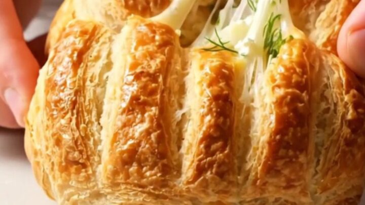Golden Turkish poğaça buns with dill and feta, broken open to show flaky interior