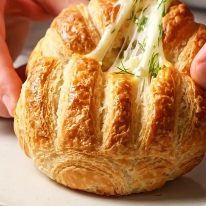 Golden Turkish poğaça buns with dill and feta, broken open to show flaky interior