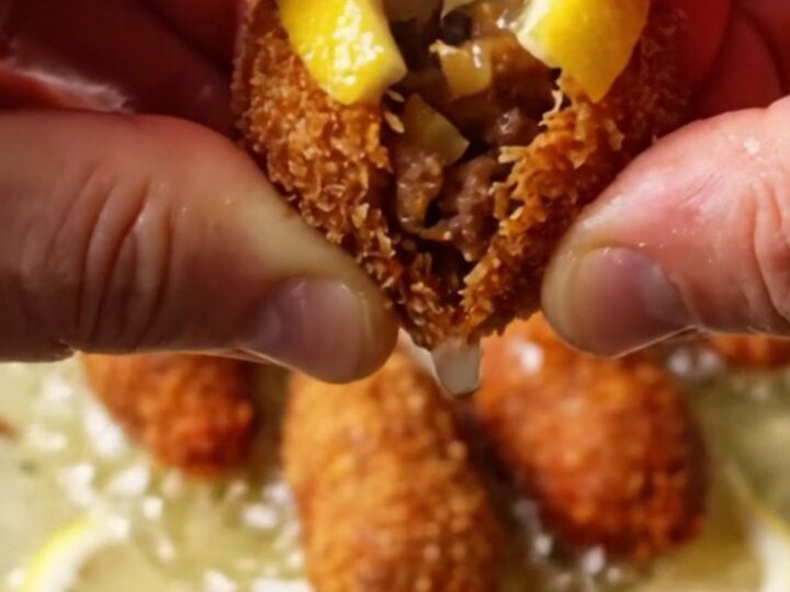 Golden crispy Turkish içli köfte on a platter with lemon wedges, showing a cracked shell with juicy filling