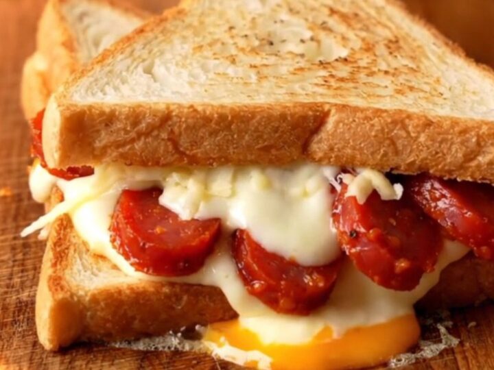 Crispy triangle toast sandwich cut open showing melted mozzarella and sucuk