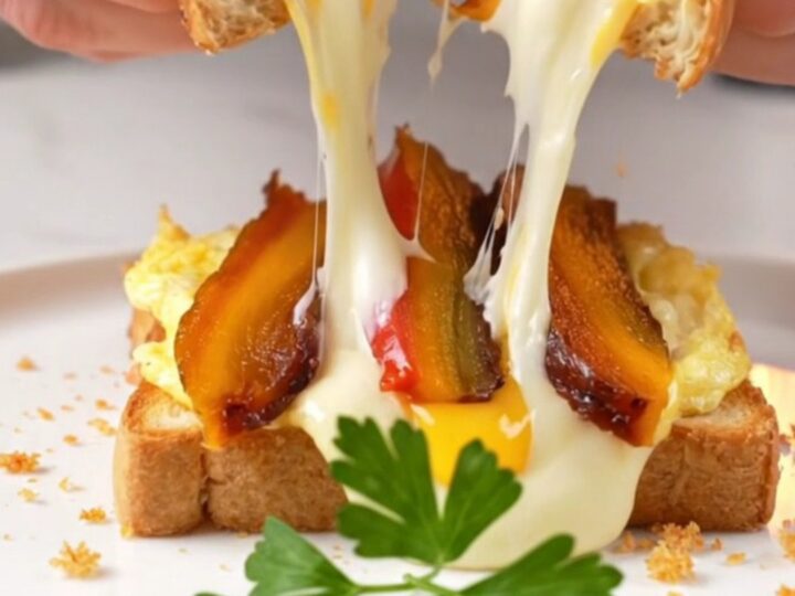 Golden crispy toast sandwich cut in half with molten cheese pull